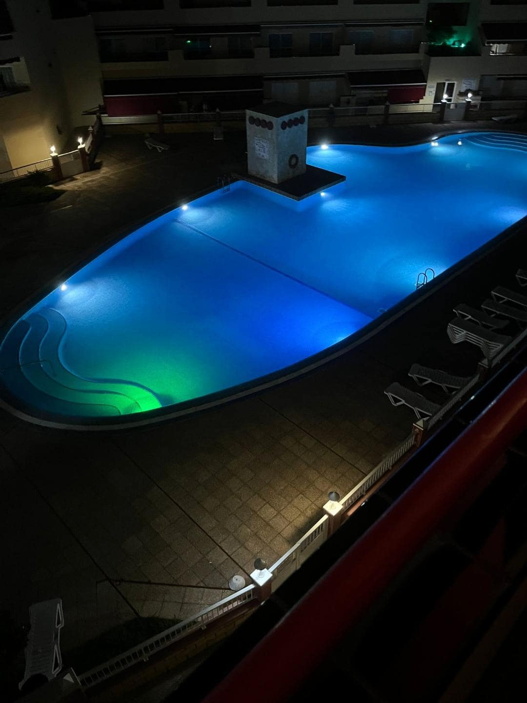 Obrovský vysvietený hotelový bazén. 