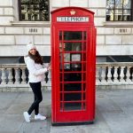 Dievča pri typickej londýnskej červenej telefónnej búdke.