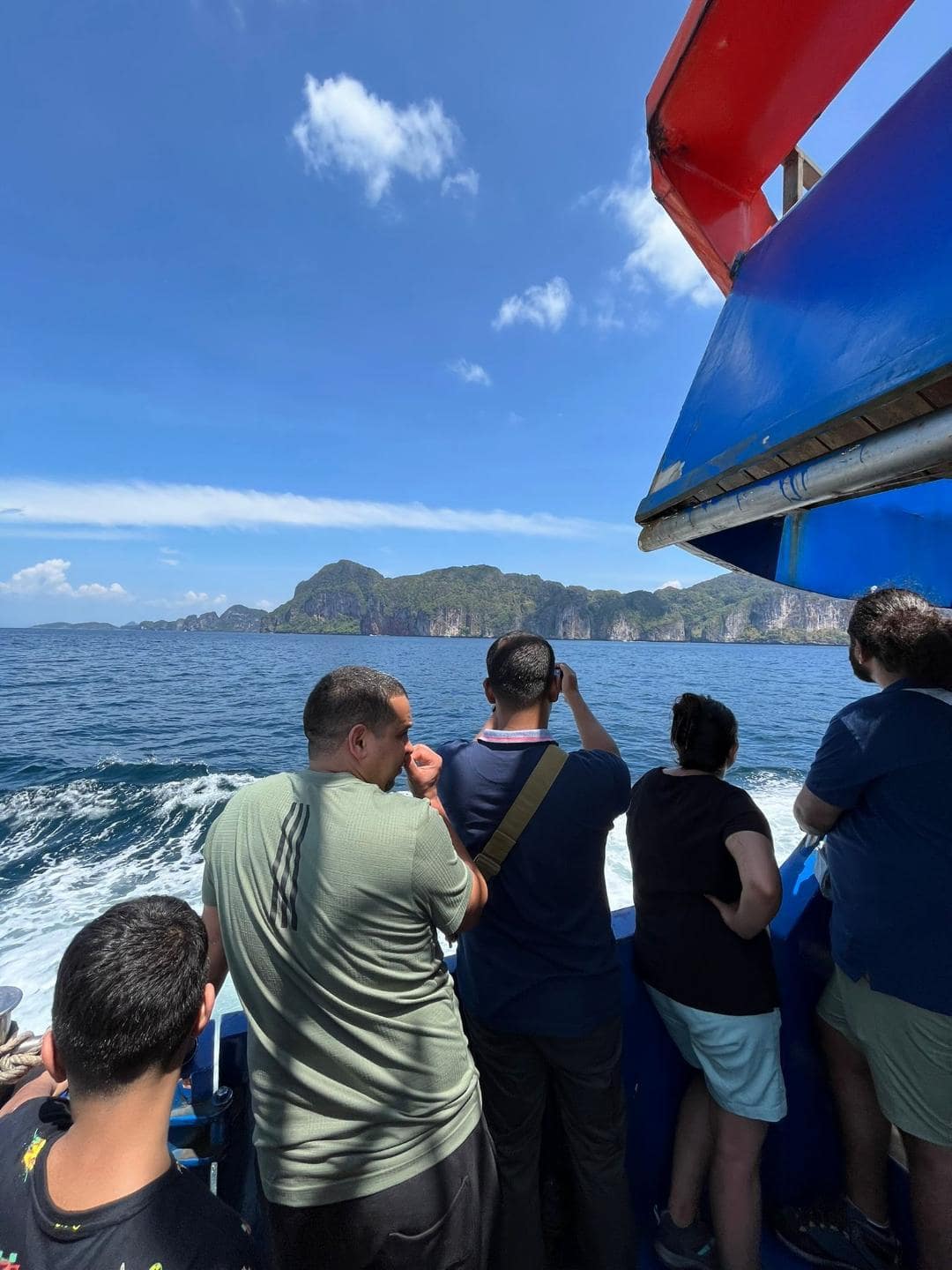 Ľudia na trajekte si fotia príchod na ostrov Phi Phi.
