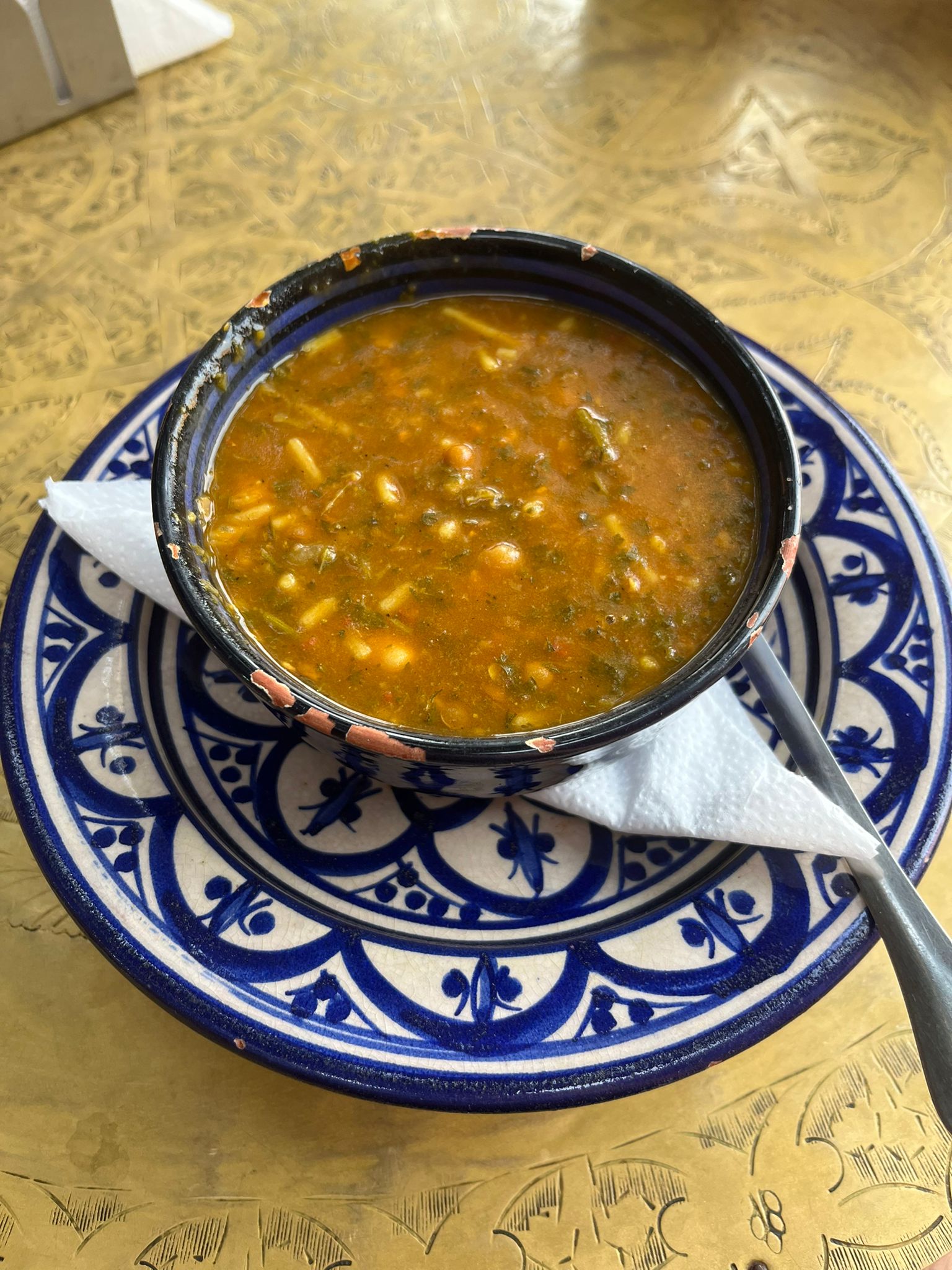 Marocká tradičná polievka so šošovicou, korením a figami, Je položená na peknom, modrobielom tanieriku.