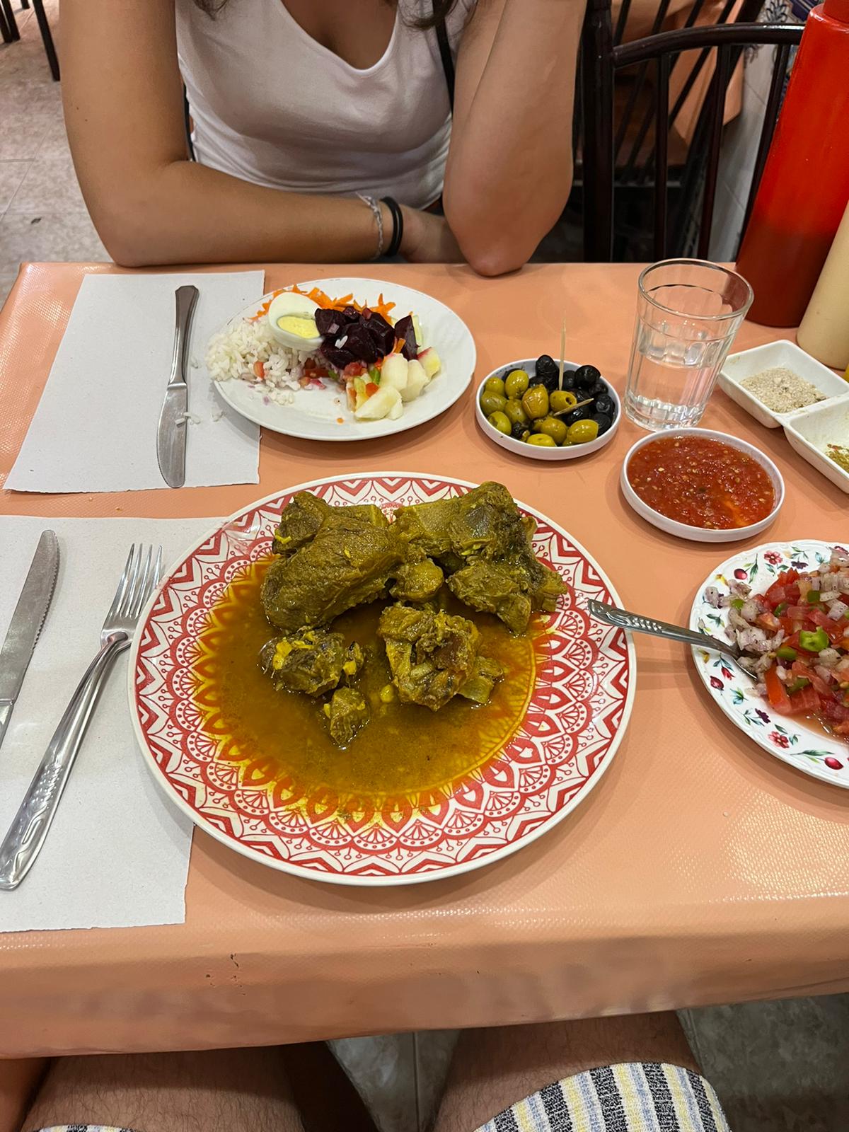 Marocké hovädzie mäso v reštaurácii. Na stole je tiež marocký šalát a olivy.