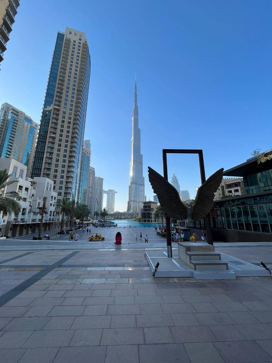 Miesto v Dubaji, kde sa turisti chodia fotiť na Instagram. Za chrtom majú anjelské krídla a v pozadí je Burj Khalifa.
