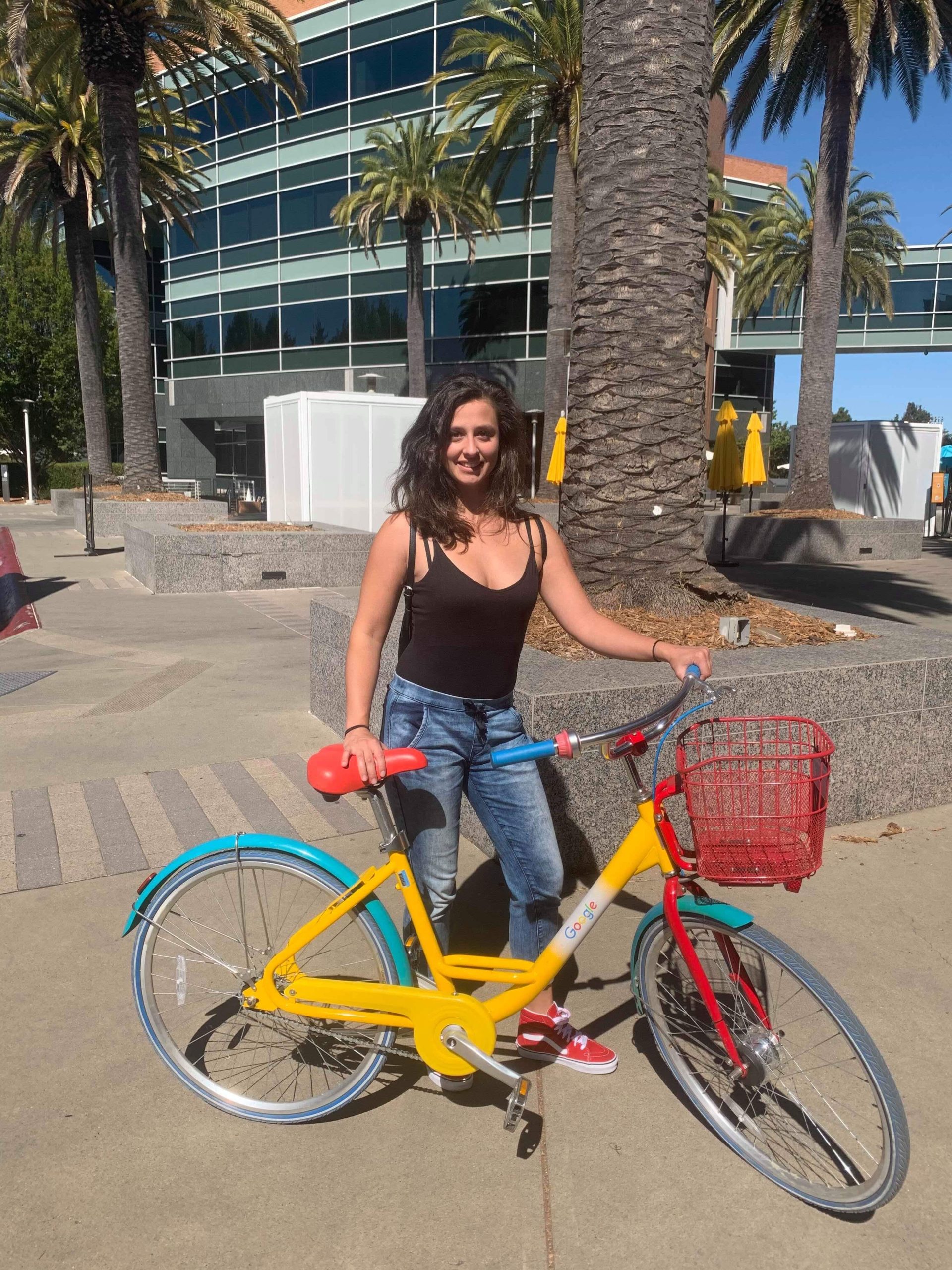 Dievča so žlto-modrým bicyklom.