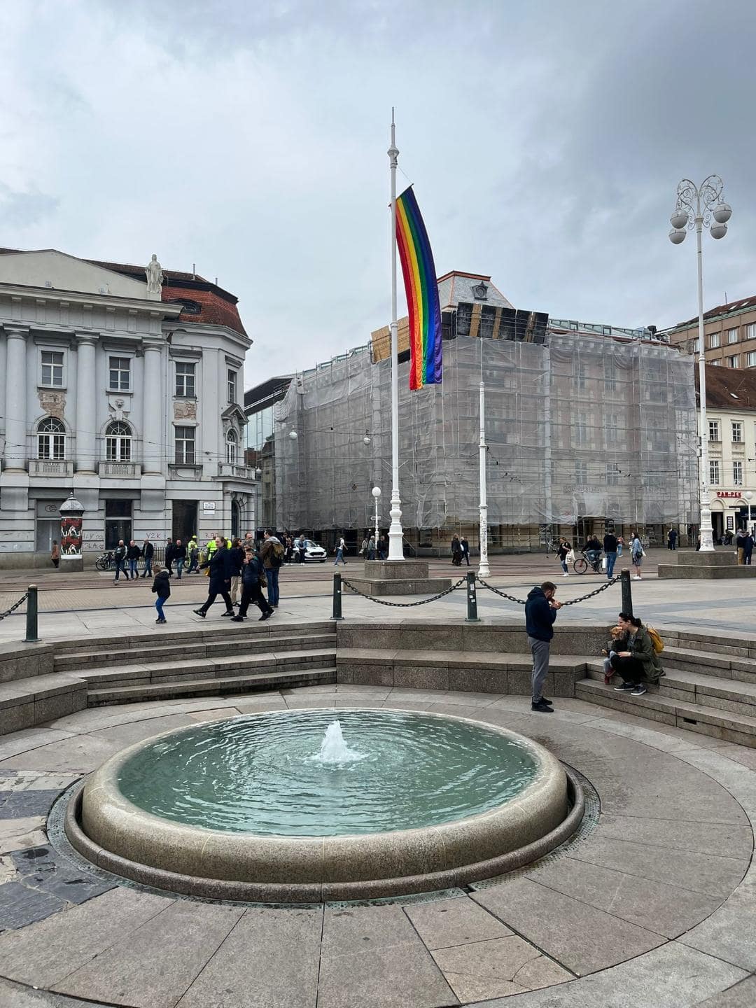 Fontána na hlavnom námestí v Záhrebe. V jej pozadí je LGBT vlajka.