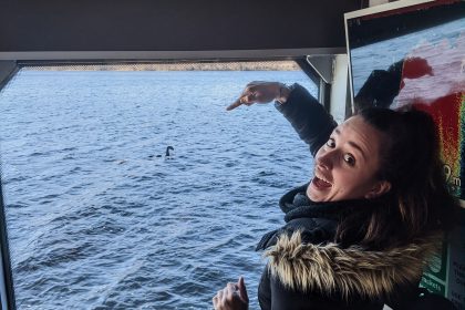 Dievča na lodi ukazuje na nálepku príšery Loch Ness.