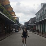 Dievča stojí uprostred slávnej Bourbon Street v New Orleans.