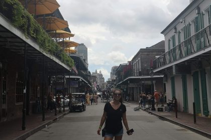 Dievča stojí uprostred slávnej Bourbon Street v New Orleans.