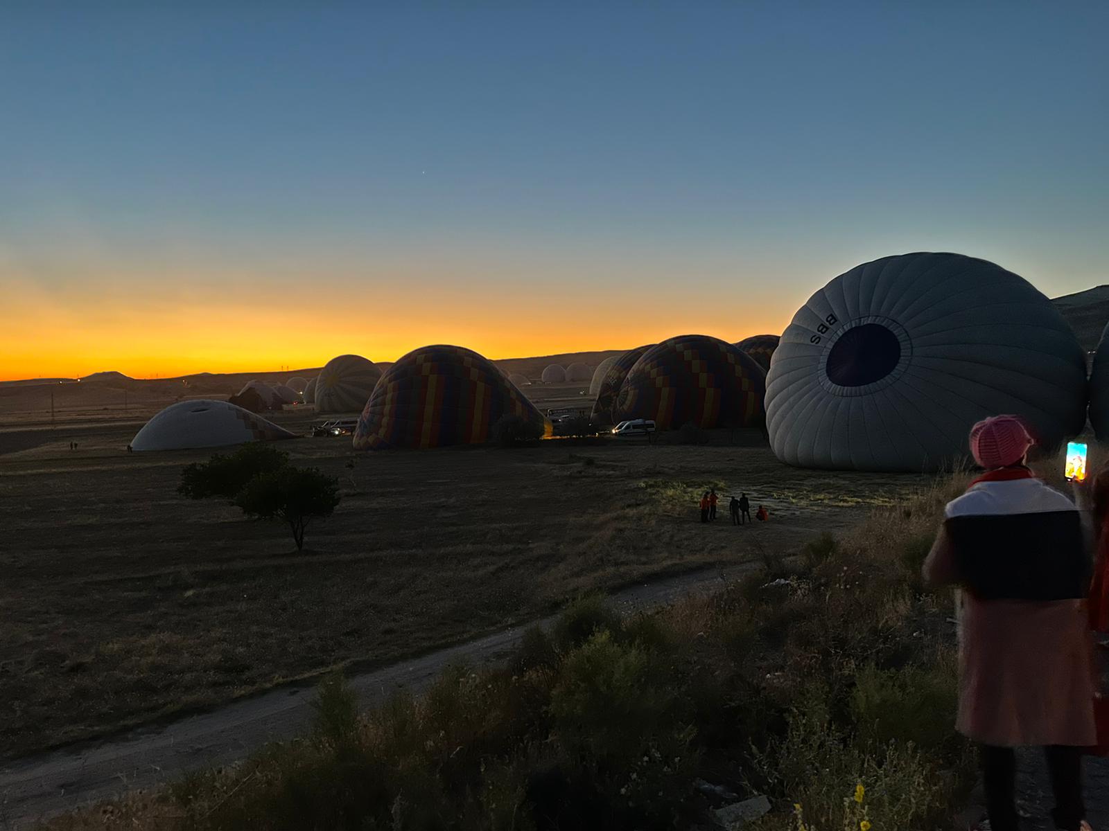 Východ slnka v Cappadocii. Na obrázku sa nafukujú vzduchom balóny.