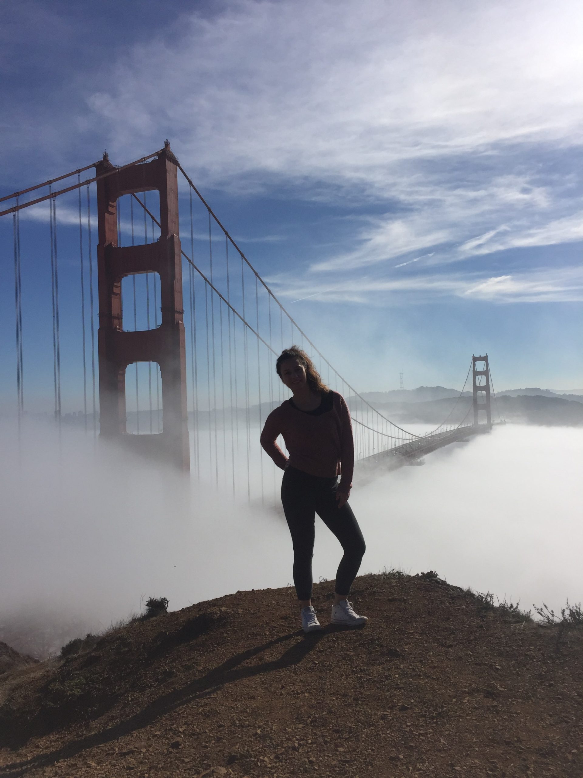 Dievča zahalené hmlou pred Golden Gate Bridge.