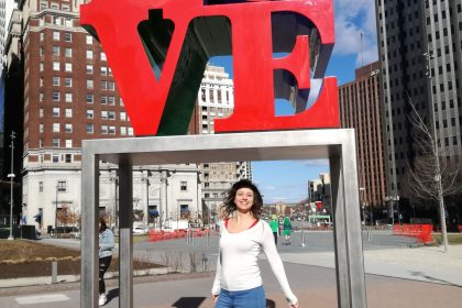 Dievča stojí na námestí pod symbolom LOVE.