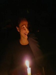 Dievča za sviečkou ukazuje vztýčený prostredník.