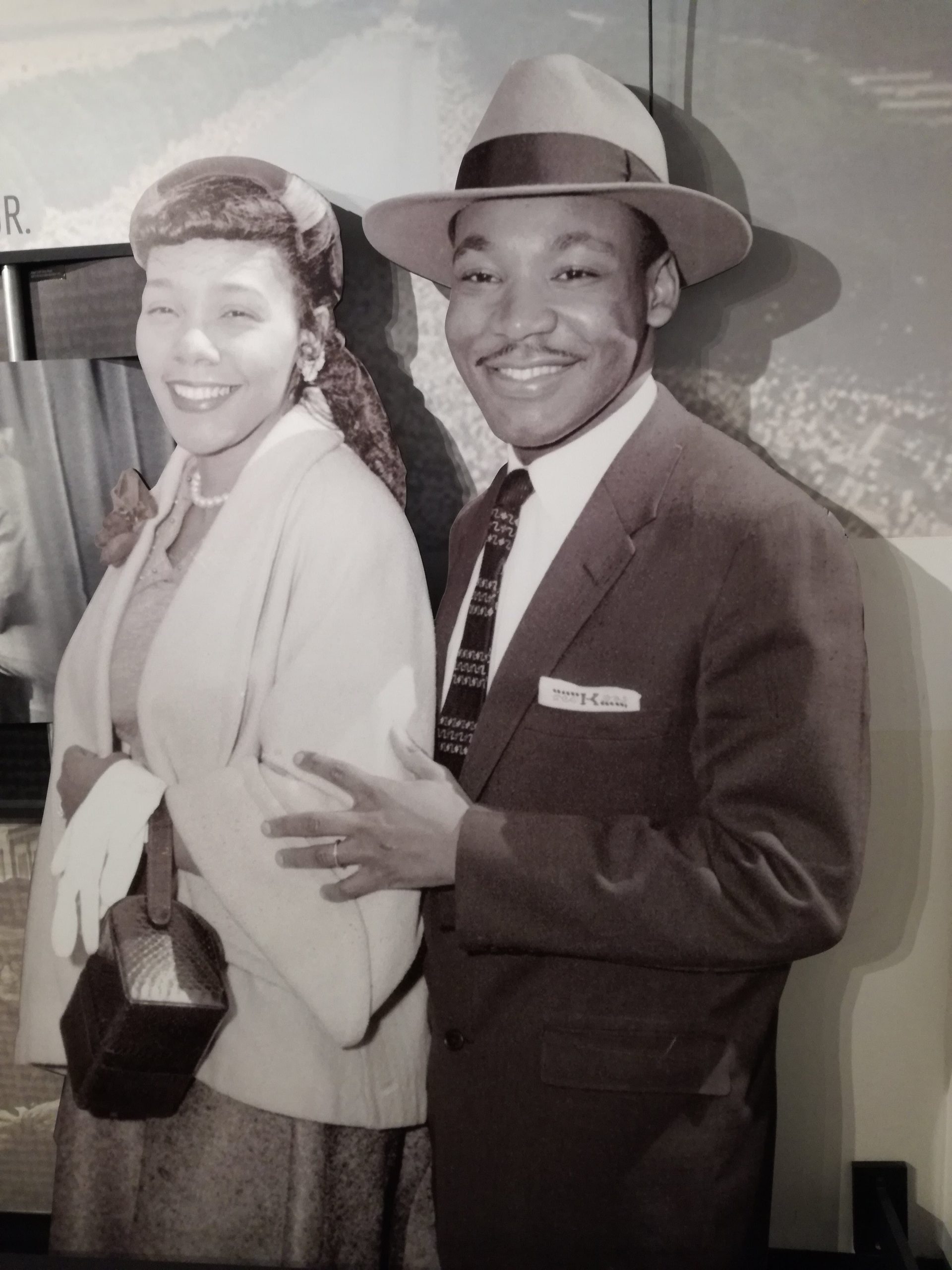 Usmievajúci chlap drží za lakeť svoju manželku. Je to čiernobiela fotka.