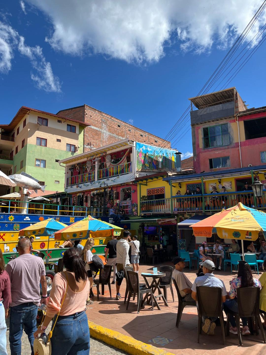 Ulica v Guatape plná turistov a kaviarní.