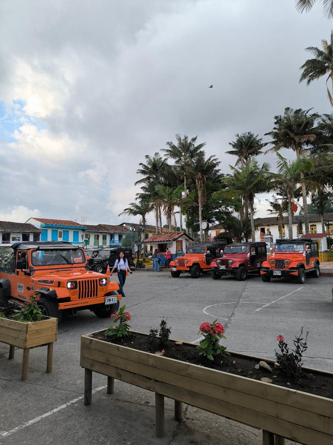 Oranžové jeepy zaparkované uprostred námestia.