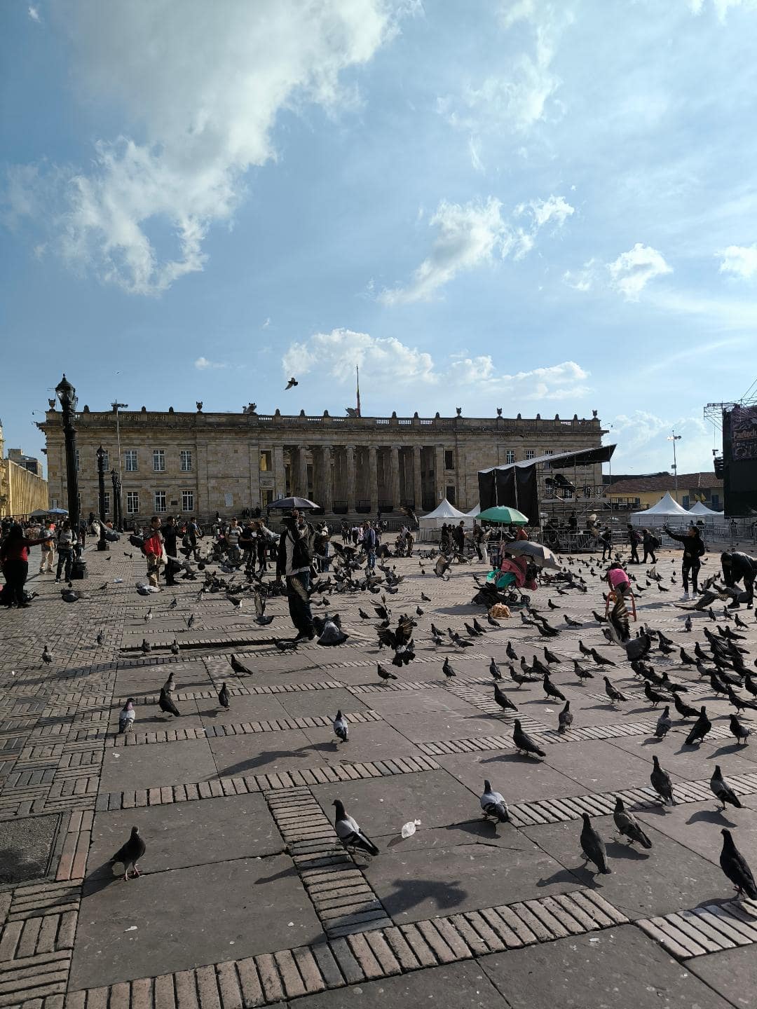 Na námestí sú stovky holubov. V pozadí je budova Justičného Paláca.