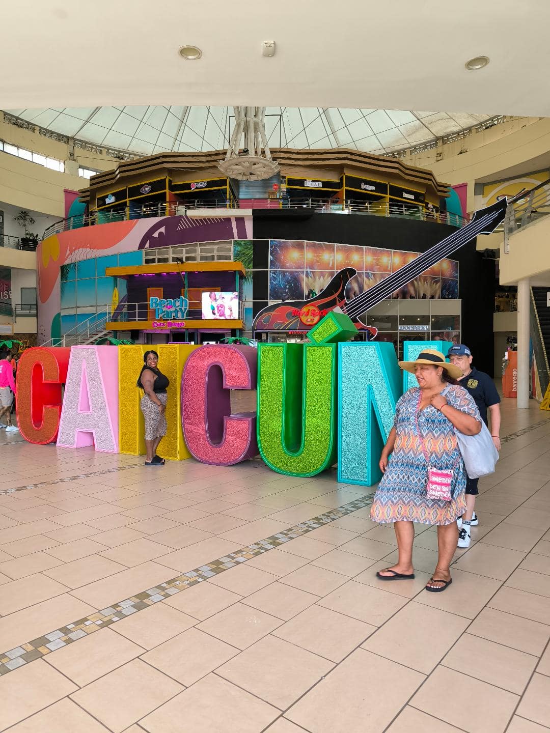 Veľký farebný nápis Cancún, pri ktorom sa fotia ľudia.