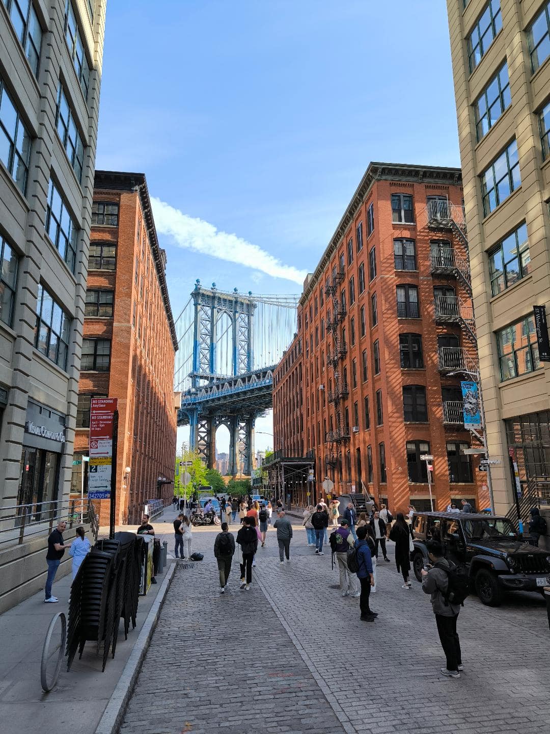 Pohľad na Brooklyn Bridge z Brooklynu. Okolo sú tehlové domy.