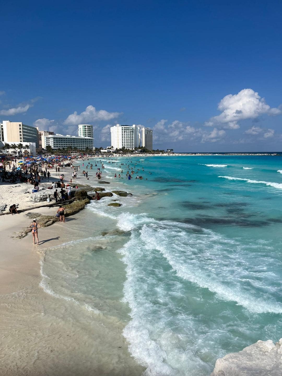 Piesočnatá pláž s azúrovým morom v meste Cancún. Nachádzajú sa tu hotely.