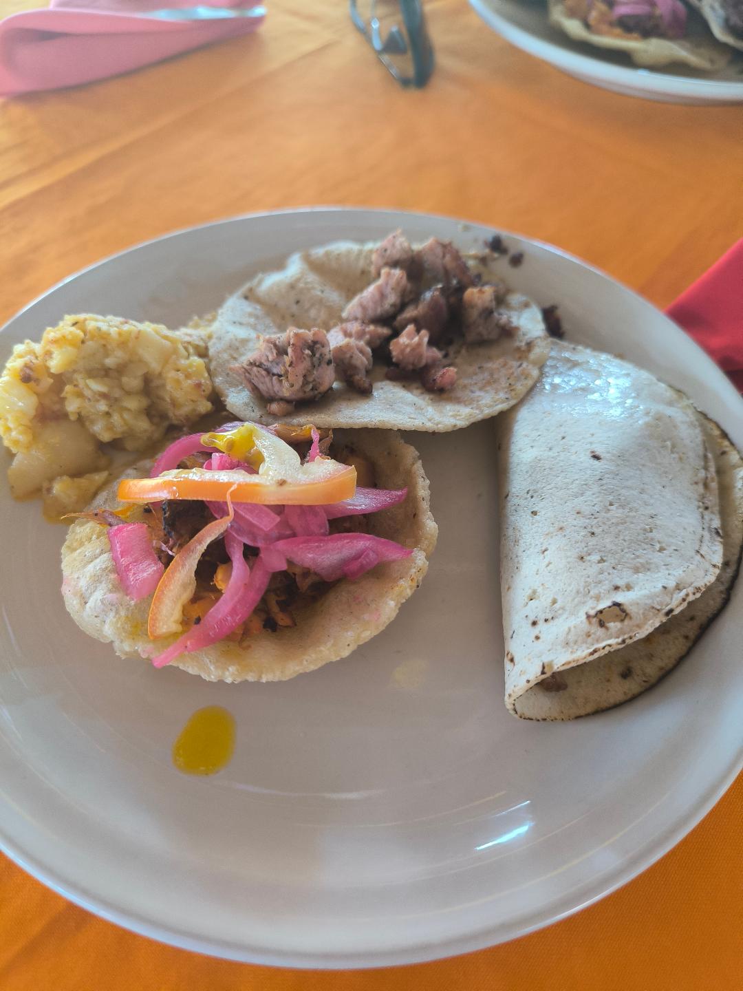 Tortilla plnená mäsom a zeleninou. Vedľa nej je zemiaková kaša.