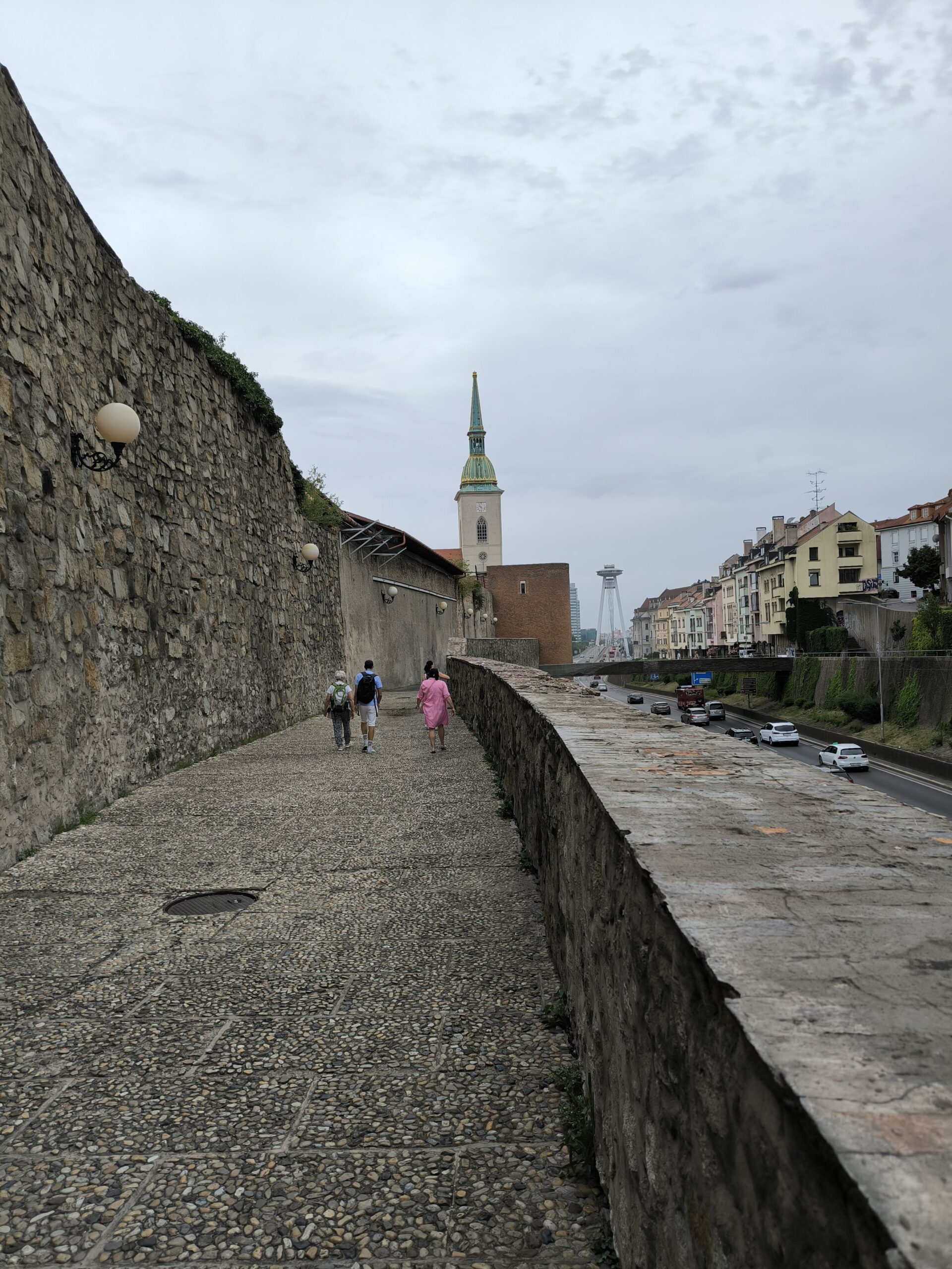 Kamenné hradby. V pozadí je dóm a vedľa nich sa tiahne hlavná cesta.