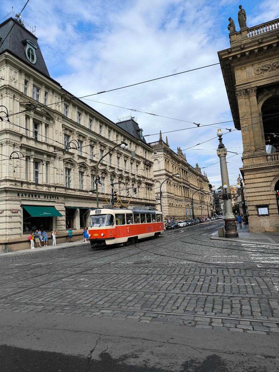 Električka jazdí po historickej ulici.