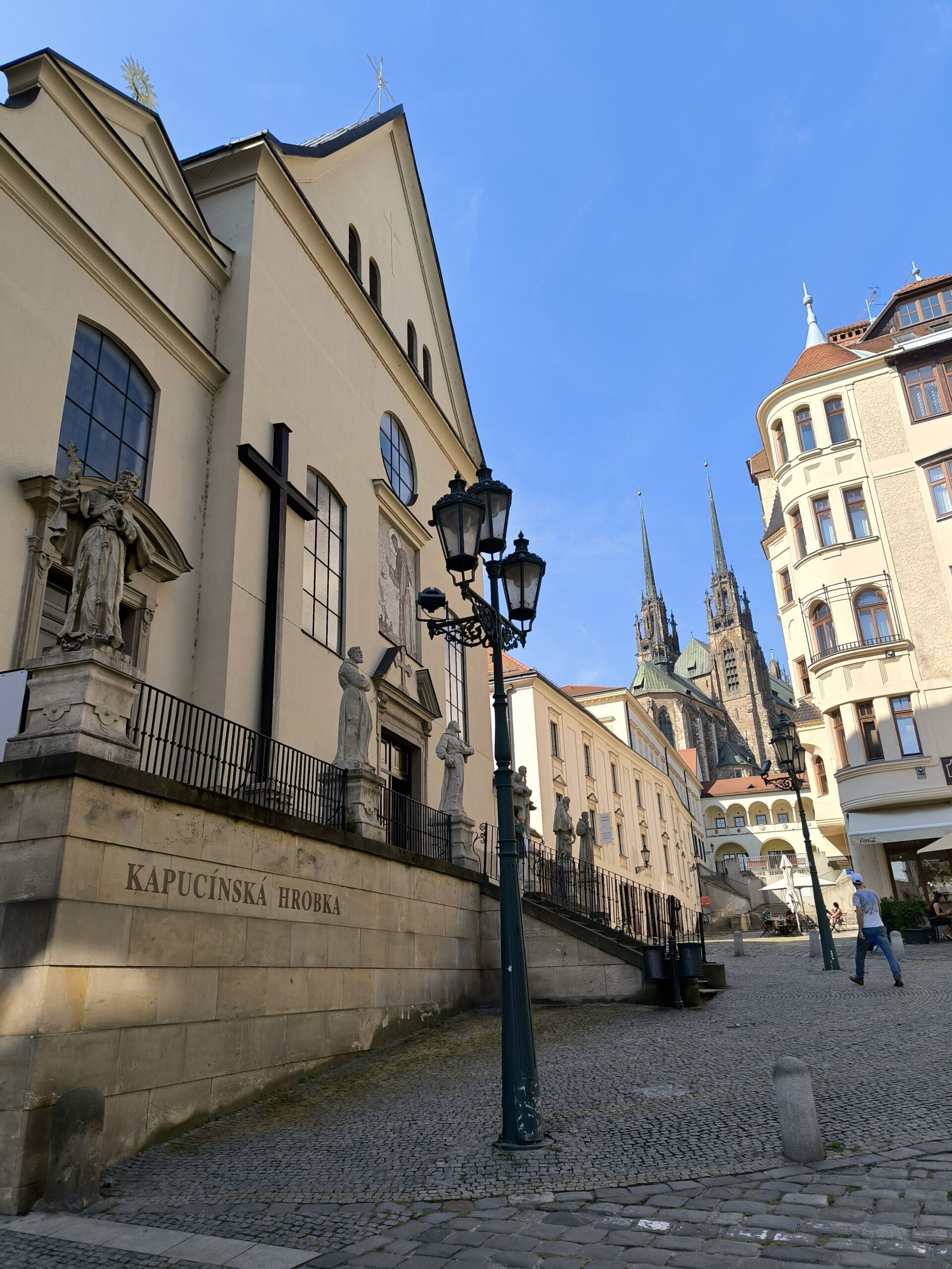 Na ulici je lampa, za ktorou sa pýši vysoká katedrála.