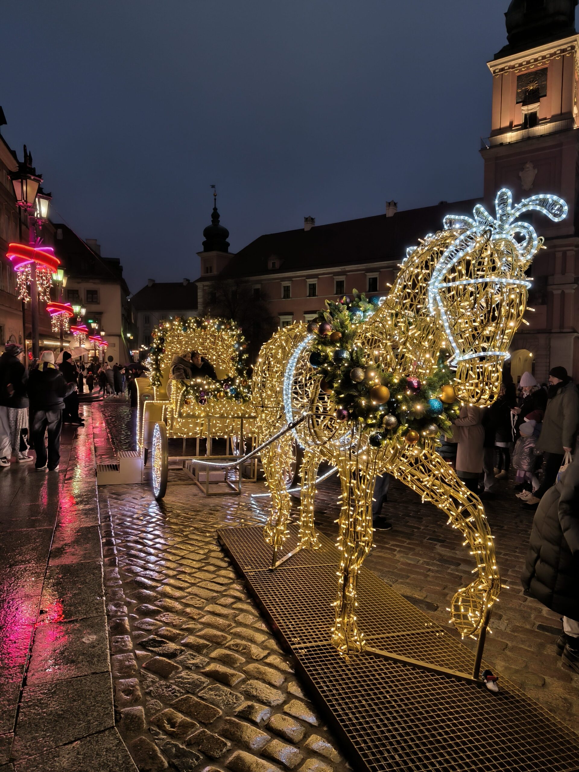 Farebná dekorácia koňa v životnej veľkosti. Okolo jeho tela sú obmotané malé svietiace lampičky.