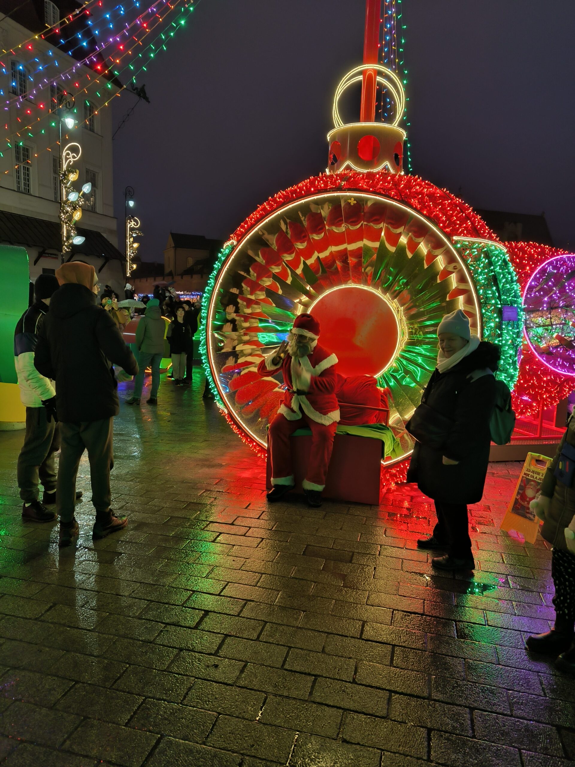 Santa Claus sedí v dekorácii vianočnej gule.