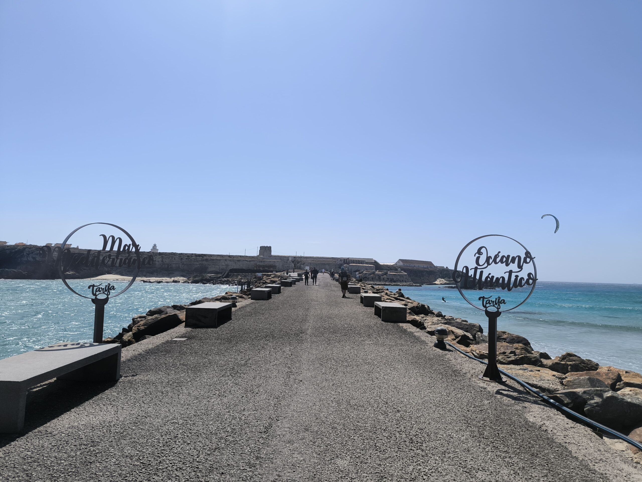Medzi morom a oceánom vedie chodníček. Na oboch stranách sú kovové tyče poukazujúce na Stredozemné more a Atlantický oceán.