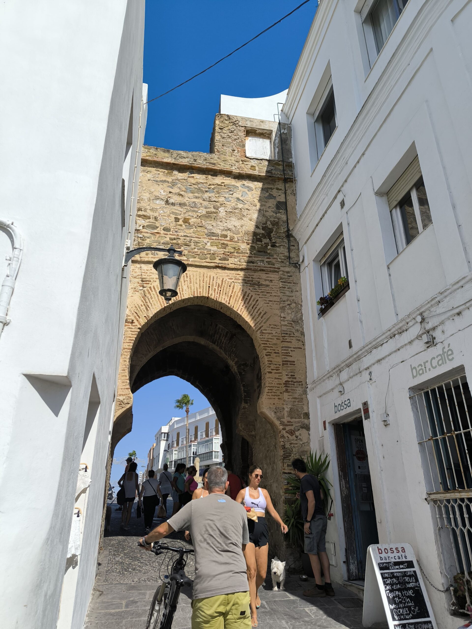 Historický kamenný marocký oblúk medzi dvoma bielymi domami.