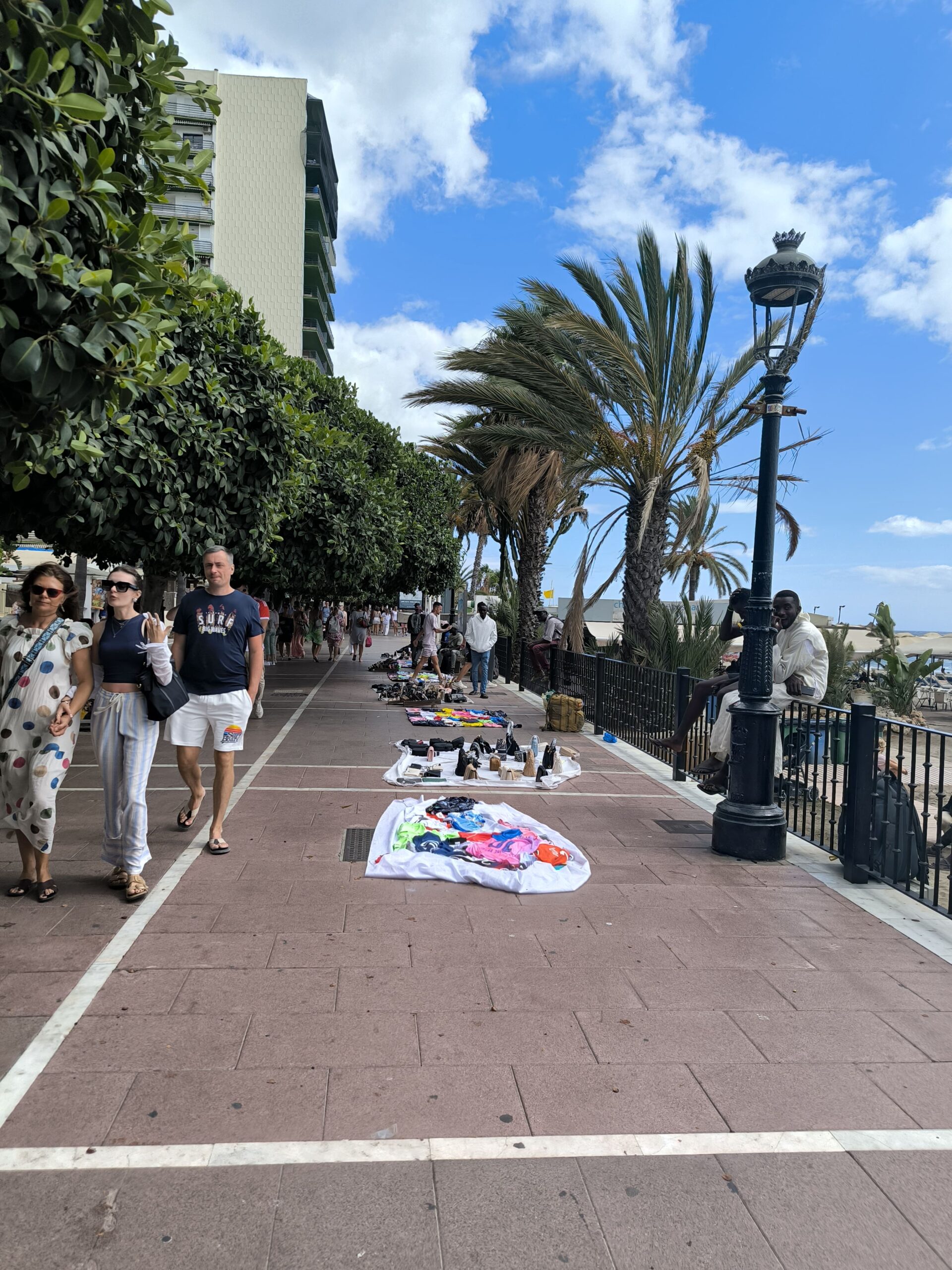 Na zemi promenády majú ľudia položené uteráky, na ktorých predávajú turistom sprostosti.